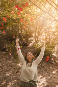 femme-joyeuse-jetant-feuilles-automne